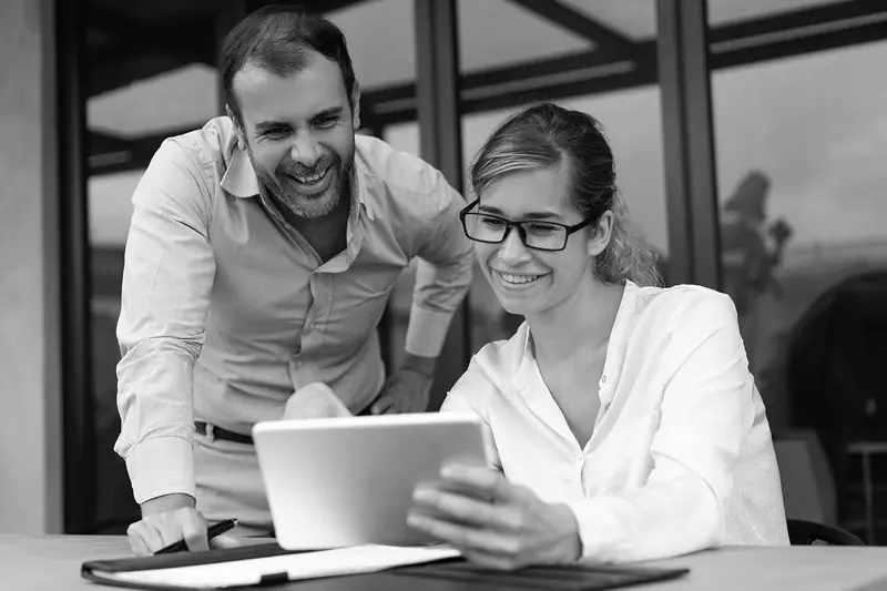 Dos colaboradores trabajando juntos con una tablet durante una capacitación